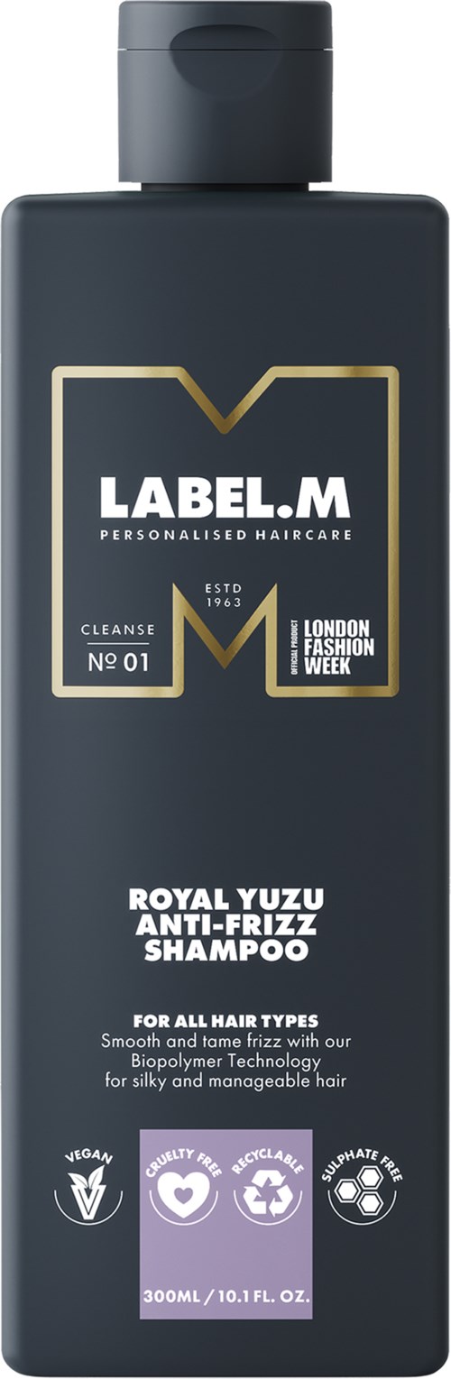 En mörk flaska med LABEL.M Royal Yuzu Anti-Frizz Schampo, för alla hårtyper, med ikoner för veganskt och kvalitet.