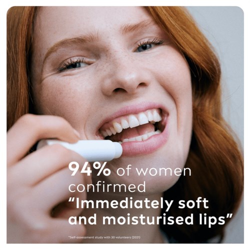 Jonge vrouw glimlacht terwijl ze lipvochtigheid test, met tekst over vrouwen die zachte, vochtige lippen bevestigen.