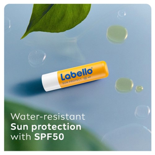 Een tube Labello zonbescherming met SPF50 drijft op water met groene bladeren eromheen.
