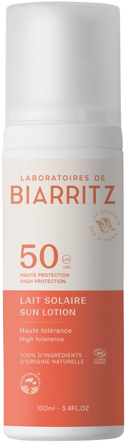 Een witte sprayfles met oranje en witte label, toont SPF 50, zonnebrandcrème met hoge bescherming.