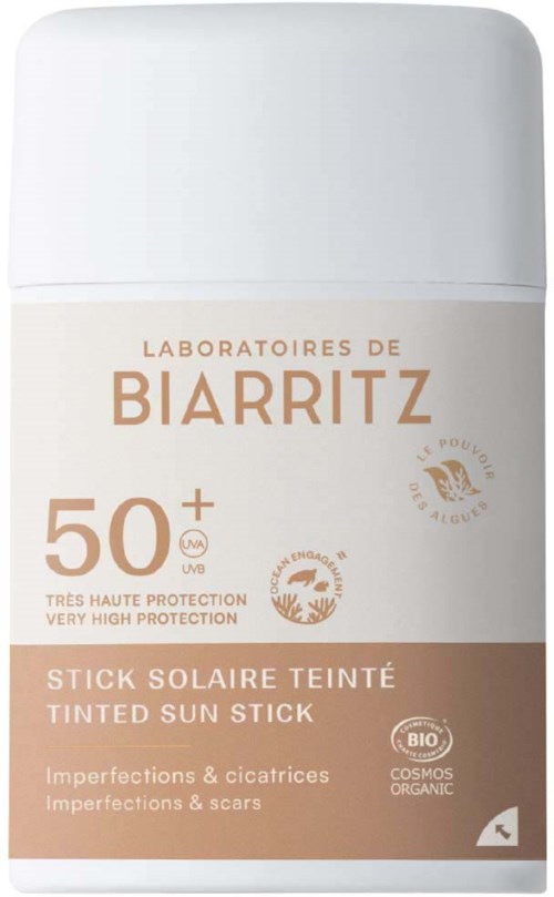 Een witte zonnebrandstick met bruine accenten, gelabeld als biologisch en hoge bescherming tegen littekens en imperfecties.