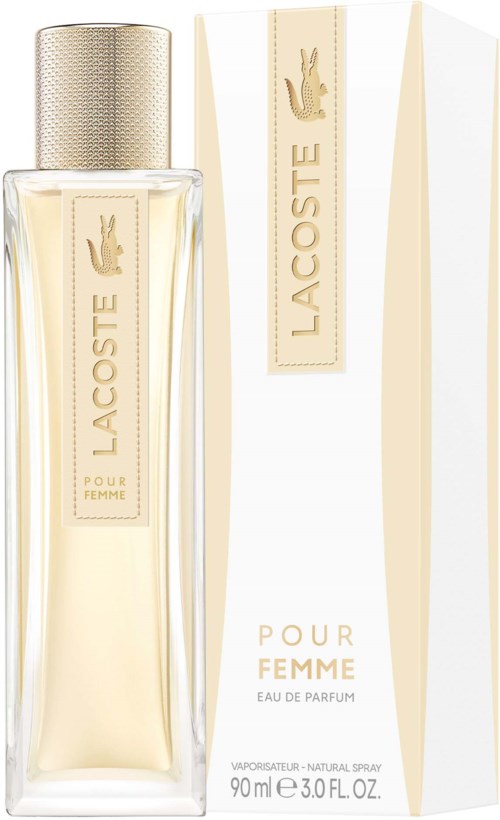Een lange, glazen parfumfles met een crèmekleurige dop en etiket, en een bijpassend wit doosje met gouden accenten.