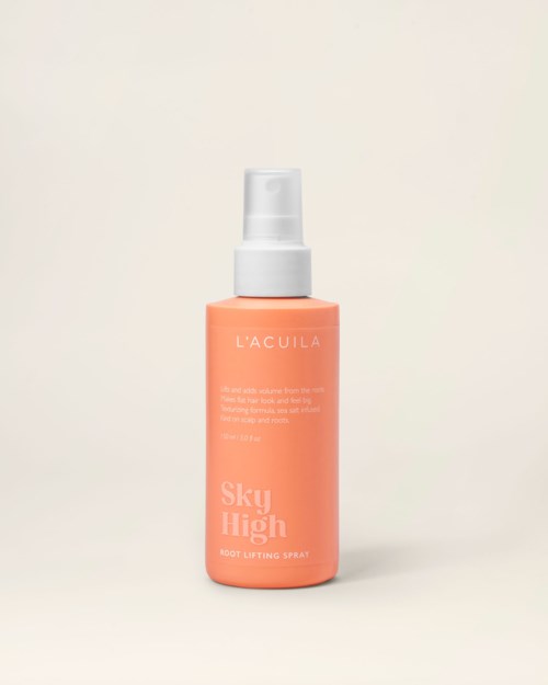 A peach-colored bottle with a white spray nozzle, labeled 'L'ACULA Sky High Root Lifting Spray.'
