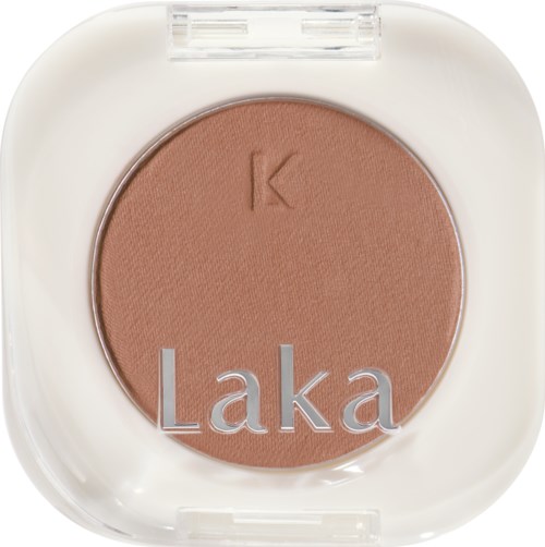 Brown pressed powder in a white compact with 'Laka' and 'K' on it.