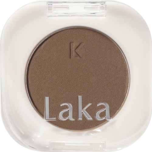 A round brown eyeshadow in a white compact case with a transparent lid, labeled 'Laka' and 'K'.