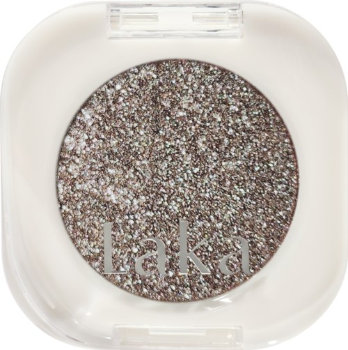 A glittery, dark eyeshadow with the brand name 'Laka' on it in a clean, white container.