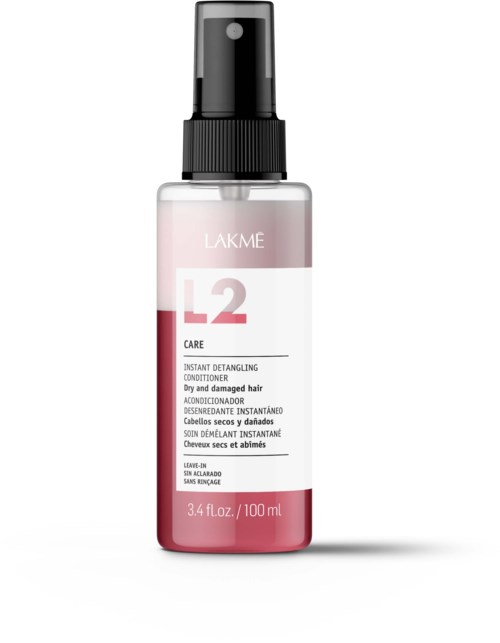 Een kleine fles gelabeld LAKME L2 Care voor droog, beschadigd haar, 3,4 fl oz, met spraydop.