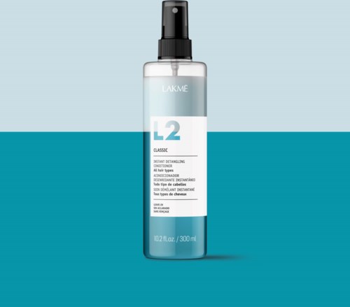 A clear spray bottle with the label 'LAKME L2 Classic,' placed against a blue background.