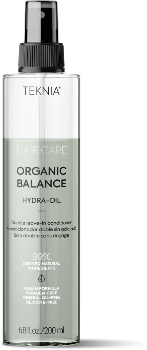 A clear plastic bottle with a black pump, labeled 'TEKNIA' and 'ORGANIC BALANCE HYDRA-OIL', contains hair care oil.