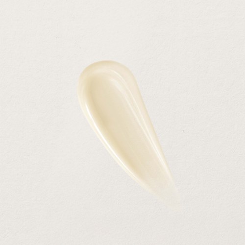 Een kleine hoeveelheid witte crème op een eenvoudige achtergrond.