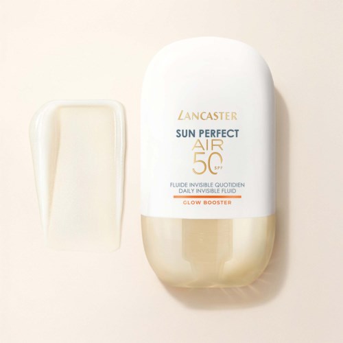 Een witte en gouden fles Lancaster Sun Perfect Air SPF 50 met een kleine, romige spons ernaast.