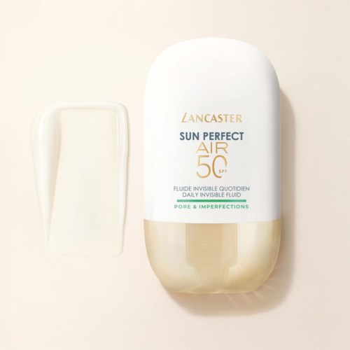 Een wit en goudkleurige fles Lancaster Sun Perfect Air SPF 50 zonnebrandcrème met tekst en een kleine hoeveelheid crème ernaast.