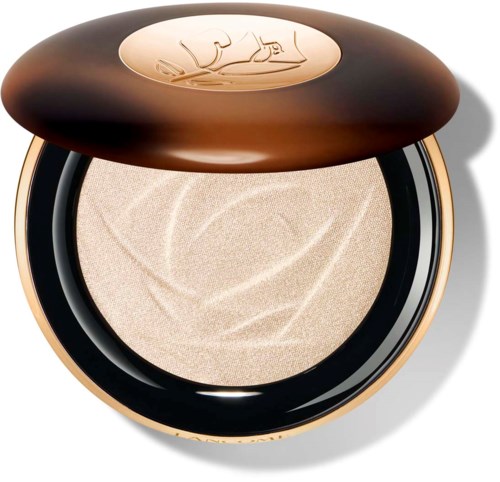 Et beige presset pulver i en rund eske med et mørkebrunt lokk. Lokket har en logo eller design på toppen.