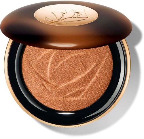 En kompakts one med skinnende brunt deksel med gulllogo og en tekstureret, ferskengul makeup inni.