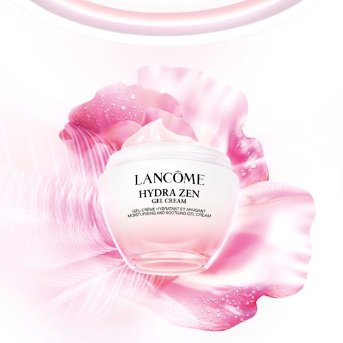 En vit burk med Lancôme Hydra Zen-gelkräm omgiven av rosa blommor och krämvirvlar.