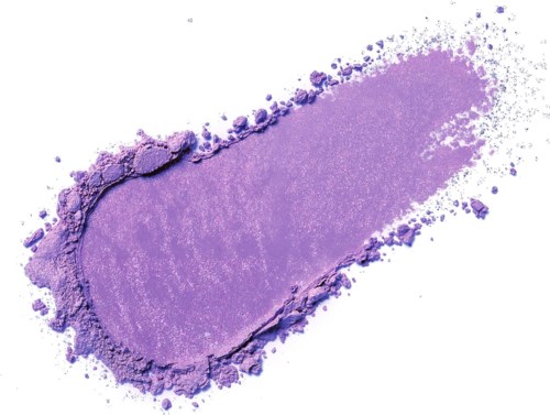 A streak of purple powder or pigment on white background, with scattered particles around.