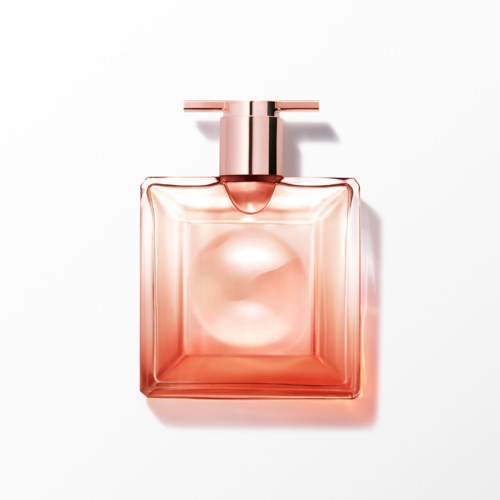 Een roze parfumfles met vierkante vorm, metalen dop en een glanzende reflectie binnenin.