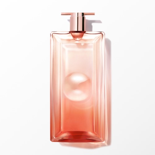 En genomskinlig rosa parfymflaska med lock, kastar en skugga på en vit bakgrund.
