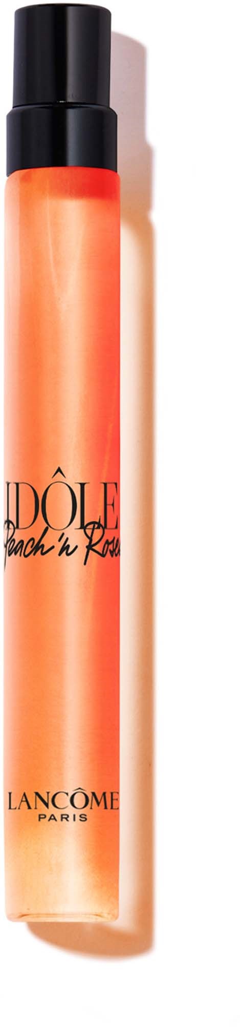 Eine lange, orange Flasche mit schwarzem Deckel, beschriftet mit schwarzem Text und Logo, enthält ein Schönheitsprodukt.