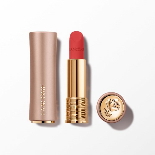 Een goudkleurige en roze lippenstift met een roos op de deksel, naast een beige case.