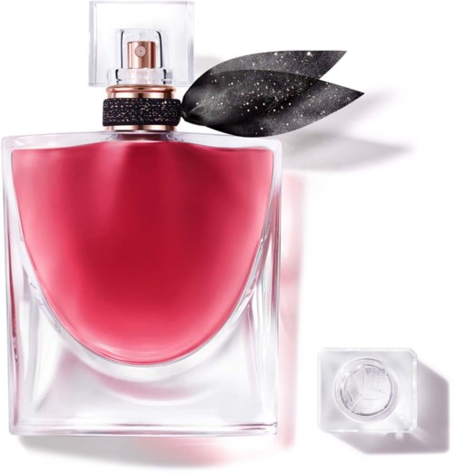 A perfume bottle with a pink liquid, black leaves with star pattern, spray cap, and clear stone-like cap.