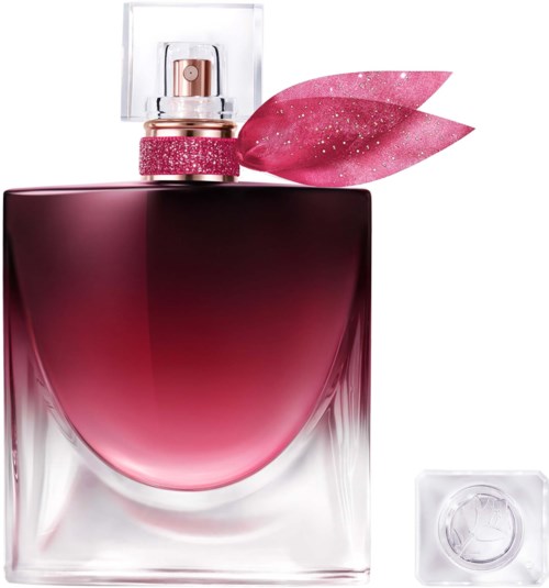 En rosa parfymflaska med klar lock, ett rosa glitterband och en rosa bladdekoration.