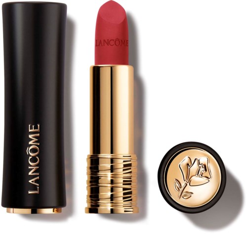 A red lipstick in a gold tube, a black case, and a small round logo with a bell and flower design.
