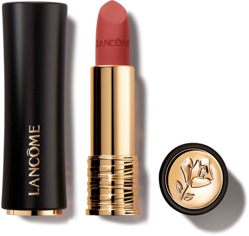 A Lancôme lipstick with a black and gold case, a pinkish shade, and a small round gold accessory.
