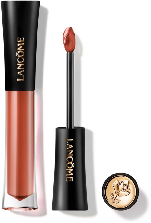 Lip gloss tube, applicator with peach-colored gloss, and a small round lid with a floral logo.