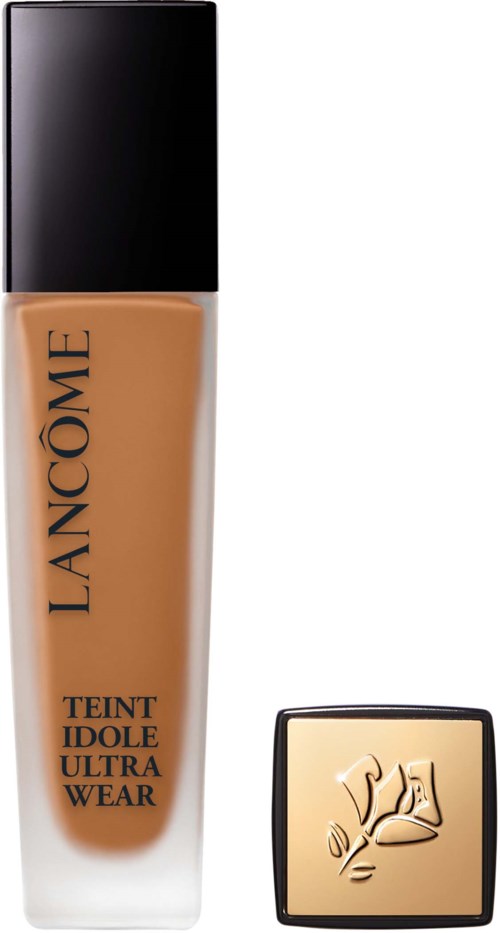 A foundation bottle with a black cap and a separate gold compact with a flower design.