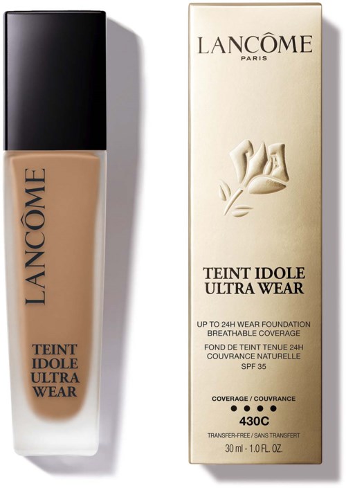 En flaska Lancôme foundation och dess förpackning, båda märkt "Teint Idole Ultra Wear," med en beige vätska inuti.