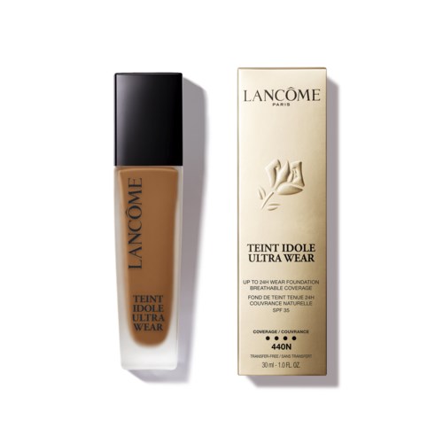 A bottle of Lancôme foundation and its box, both with beige and black colors, and text details.
