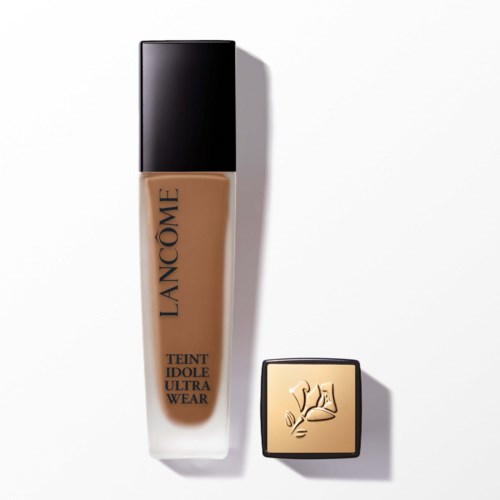 A bottle of Lanc f4me foundation and a small compact with a gold face and hand design.