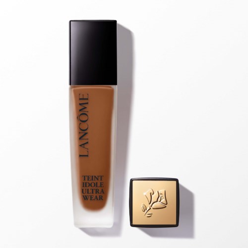 A bottle of foundation and a small square container with a gold lid and a raised hand logo.