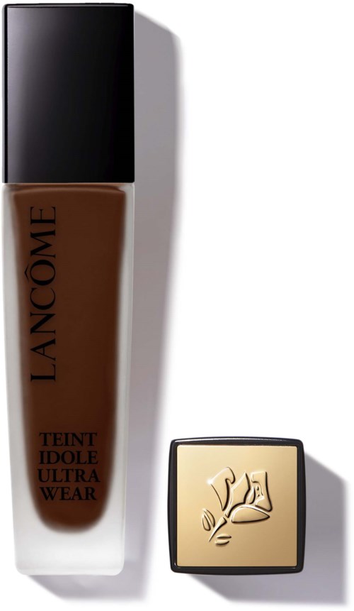 A bottle of Lancôme foundation and a small square compact with a rose logo. Both are on a white surface.