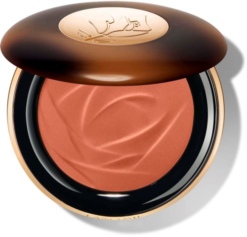 En rund makeup-rouge i en mørk brun eske med gulldetaljer, viser en rosa farge innvendig.