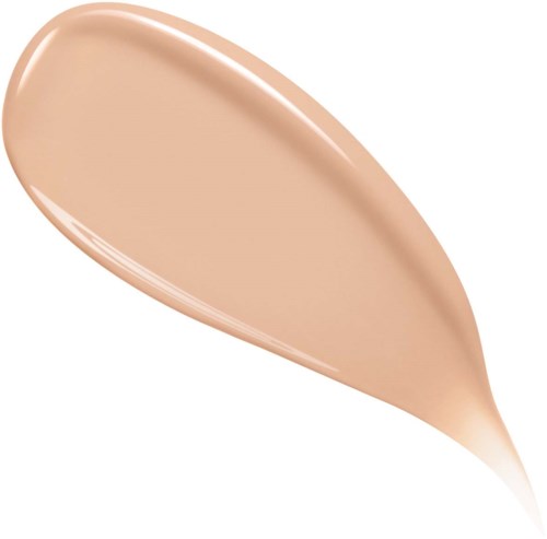 A beige makeup product, likely foundation, with a smooth, creamy texture on an applicator sponge.