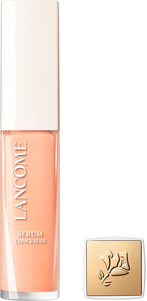 A bottle of Lancôme serum concealer with a golden compact beside it, both on a white background.