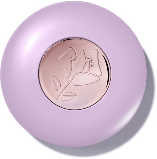En rund blush med et blomsterdesign på overflaten, omgitt av en lilla-lilla emballasjedåse.