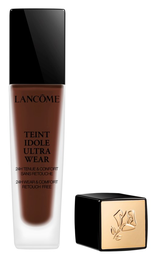 En flaska foundation från Lancôme med svart lock och ett guldlogglås bredvid.