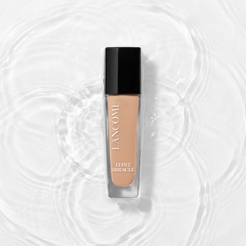 Een fles Lancôme Teint Miracle vloeibare foundation op watergolven.
