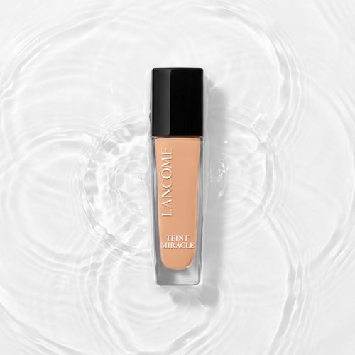 Een fles Lancôme Teint Miracle foundation op watergolven achtergrond.