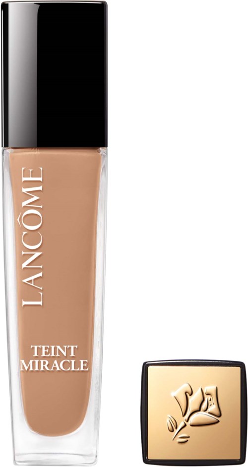 Een make-up foundationfles met een zwart deksel en een gouden compacte met bloemenontwerp.