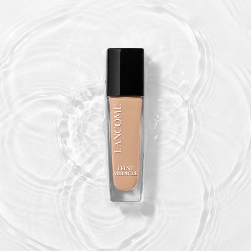 Lancôme Teint Miracle foundationfles ligt op water met rimpels.