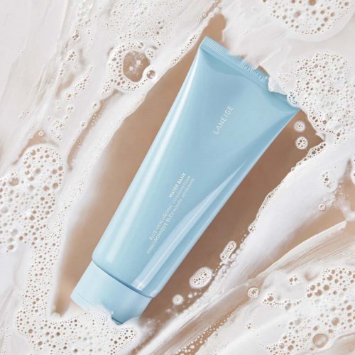 Een blauwe tube Laneige huidverzorging ligt in zeepwater met schuim en bellen eromheen.