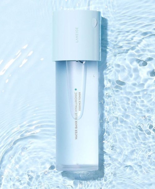 Een witte fles gemerkt 'WATER BANK BLUE HYALURONIC ESSENCE TONER' drijft in helder water.