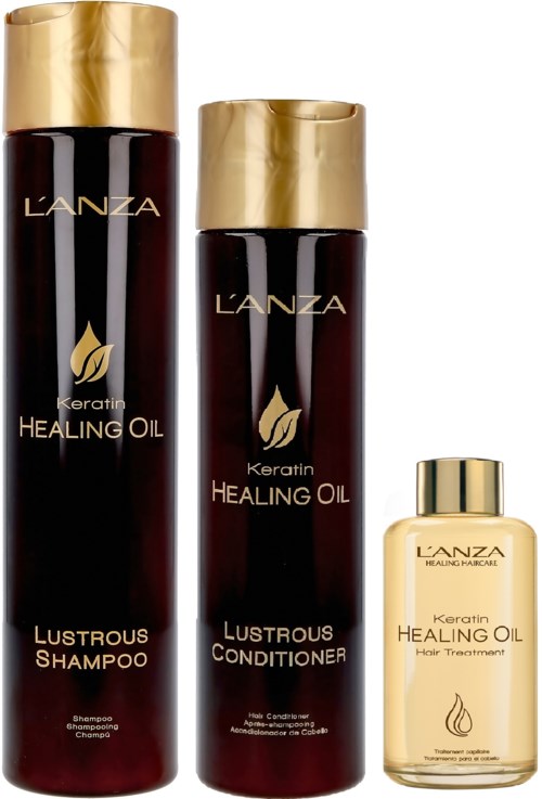 Drie L'ANZA-haarproducten: shampoo, conditioner en behandelingsolie, allemaal met gouden deksels en donkere flessen.