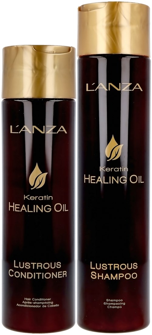 Twee donkere flessen met gouden doppen, gelabeld 'Healing Oil' en 'Lustrous Shampoo', met gouden blad-symbolen, tegen een lichte achtergrond.
