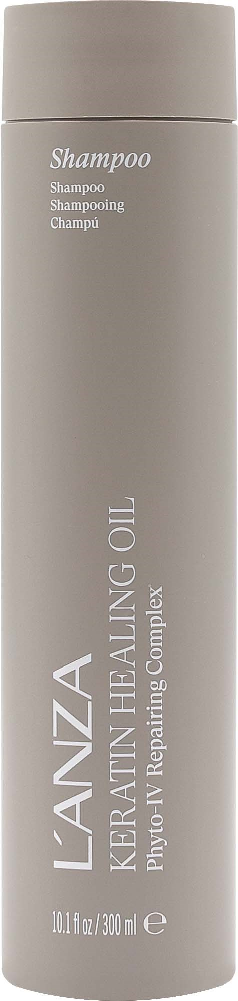 En lång, smal flaska med L'ANZA Kerashape Healing Oil schampo med vit etikett och silverlock.