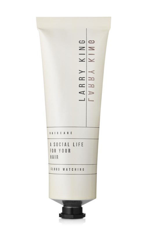 Eine weiße Tube Haarpflegeprodukt mit schwarzem Verschluss, gekennzeichnet 'Larry King' und 'A Social Life for Your Hair.'